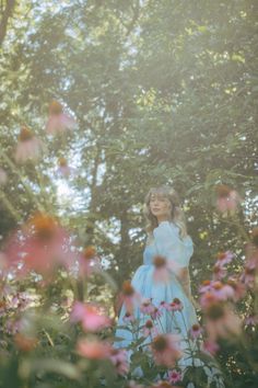 a woman standing in the middle of flowers