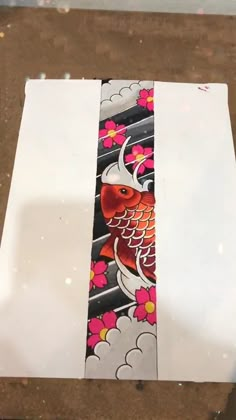 a tie that is sitting on top of a piece of paper with an image of a koi fish on it