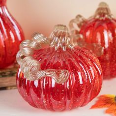 three red glass pumpkins sitting next to each other