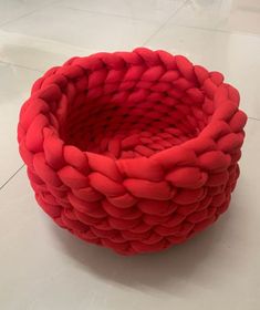 a red basket sitting on top of a white floor