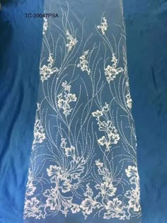 the fabric is blue with white flowers and leaves on it's side, as well as