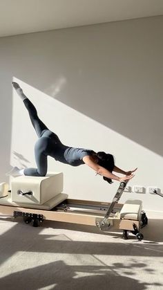 a woman is doing an exercise on a treadmill in the middle of a room