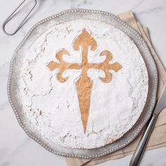 a cake with white frosting and gold fleur de liqueur on it