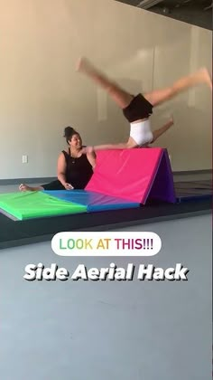 two women doing tricks on an inflatable trampoline