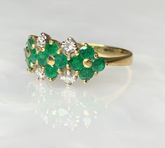 Emerald Flower Ring, Emerald Ring For Women, Emerald Ring Vintage, Natural Emerald Ring, Emerald Dainty Ring, Emerald Solid 18k Gold Ring A delightful vintage solid 18k gold floral ring featuring 12 lively green round emeralds weighing 0.75 carats forming 3 flowers side by side while accented by 4 sparkling white diamonds weighing 0.15 carats. *Ring size: US 7 1/2 * Complimentary resizing is available up to 3 sizes larger or smaller than stated size. Formal Multi-stone Yellow Gold Flower Ring, Diamond Multi-stone Flower Ring, Flower Shaped Diamond Ring With Multi-stones, Fine Jewelry Flower-shaped Multi-stone Rings, Elegant Multi-stone Flower Ring, Elegant Flower-shaped Multi-stone Rings, Fine Jewelry Multi-stone Flower Promise Ring, Yellow Gold Flower-shaped Multi-stone Rings, Yellow Gold Flower-shaped Rings With Multi-stone