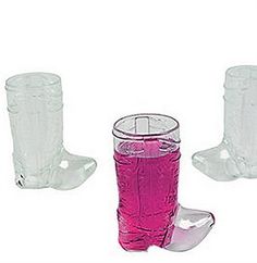 three clear glass cups and one pink plastic cup are sitting next to each other on a white background