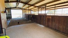 the inside of a horse barn with several stalls