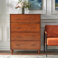 a wooden dresser sitting next to an orange chair