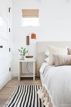 a bedroom with a bed, chair and pictures on the wall