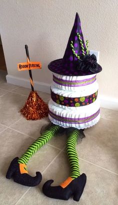 a stack of halloween hats sitting on top of a tiled floor next to a broom