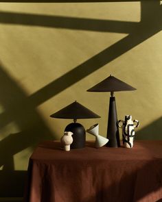 three lamps sitting on top of a table next to a vase and two other items