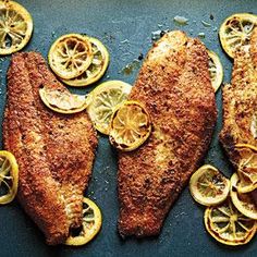 fish with lemon slices and seasoning on the side