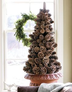 a pine cone christmas tree sitting on top of a window sill next to a couch