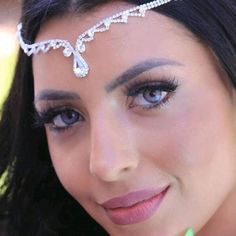 a close up of a woman wearing a tiara and holding a toothbrush in her hand