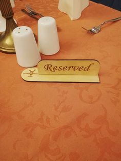 the table is set with two salt and pepper shakers on it, along with a reserved sign