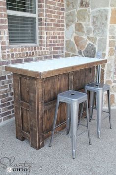 two stools are sitting at the bar in front of a brick building