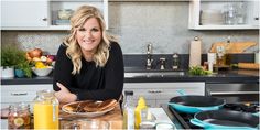 a woman sitting at a kitchen counter with food