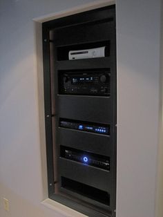 an entertainment center in the corner of a room with speakers and other electronic equipment on it