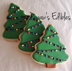 three decorated cookies with christmas trees on them