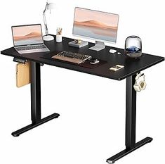 a computer desk with two laptops on it