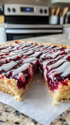 a cake with white icing and berries on it sitting on a counter next to a stove