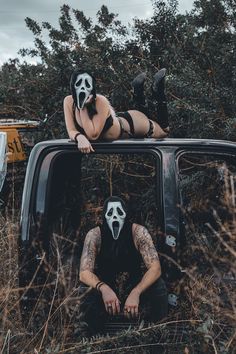 two people with masks sitting in the back of a pick up truck