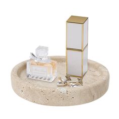 a white and gold object sitting on top of a marble tray next to other items