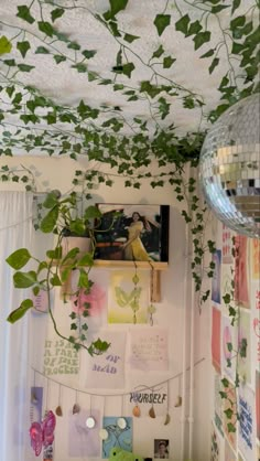 a room with ivy growing on the ceiling and pictures hanging from the wall above it