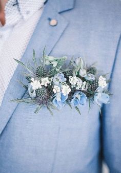 a man in a blue suit and white flowers on his lapel flower pinhole