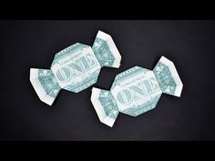 two origami fish made out of one dollar bill on black background with space for text