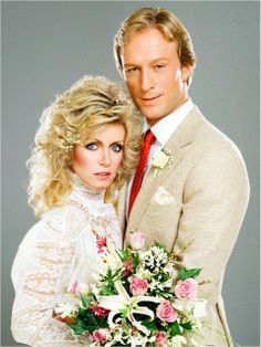 a man and woman dressed in wedding attire posing for a photo with flowers on the bouquet