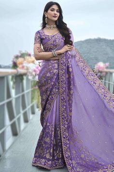 Exhibiting elegant embroidery and stitch detailing, this lavender-purple viscose saree will surely make a statement.This u-neck and short-sleeve blouse is decorated using resham thread, sequins, stone, mirror, and dori work.It is accompanied by a matching viscose ombre saree in lavender purple color adorned with woven zari, printed, resham thread, sequins, stone, mirror, and dori work.This saree blouse can be customised up to the maximum size available in inches 58 around the bust. Slight color variation may occur due to photographic reasons. Lavender Color Lehenga, Light Purple Saree, Lavender Saree, Ombre Saree, Lavender Purple Color, Purple Lehenga, Dori Work, Stone Mirror, Purple Saree