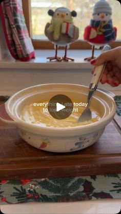 someone using a spoon to dip cheese into a bowl