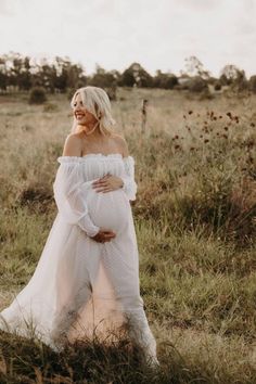 a pregnant woman standing in a field