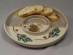 two slices of bread sit on a plate with seasoning in the bowl next to it