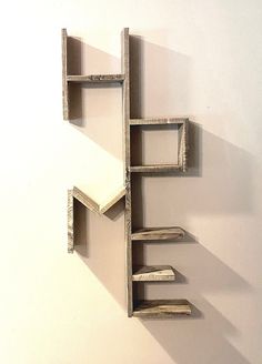 a book shelf made out of wood with shelves on each side and one section missing from the wall