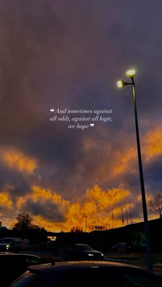 a street light sitting next to a parking lot under a cloudy sky