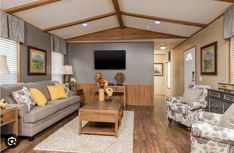 a living room filled with furniture and a flat screen tv mounted to the wall over a fireplace