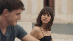 a woman sitting next to a man on a bench