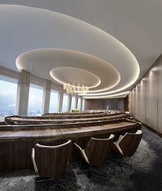 an empty conference room with wooden benches and chandelier in the center, along with floor to ceiling windows