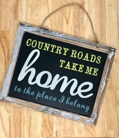 a sign that says country roads take me home to the place i belong on it