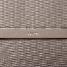 the word nortivl is written in silver on a beige leather case with metal handles