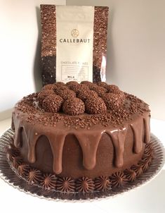 a chocolate cake sitting on top of a glass plate next to a bag of coffee