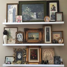 there are many framed pictures on the shelves