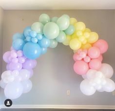 a bunch of balloons that are in the shape of a rainbow