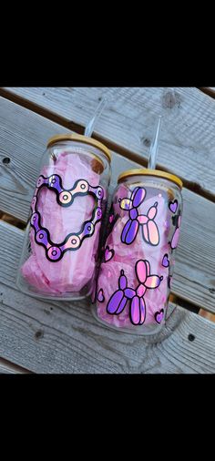 two canisters with pink and purple designs on them