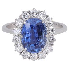 G.I.A. No Heat Ceylon Sapphire & Diamond Halo Handmade Princess Diana Style Ring Sapphire - Natural Weight - 3.93 Carats Measurements - 10.57 x 7.73 x 5.47mm Shape - Oval Treatment - No Gemological Indications of Treatment Origin - Ceylon / Sri Lanka G.I.A. Report # 5221483304 Ring: Diamonds - 14 Round Brilliant Cut = 1.40 carats Color - D-G Clarity - VS1 - VS2 Metal - 18 Karat White Gold Weight - 5.1 Grams Top Dimensions - 16.5 x 13.5mm Size - 7 US Tiffany Co Rings, Sapphire Cocktail Ring, 14k White Gold Diamond Ring, Tanzanite Diamond Ring, Tanzanite Diamond, Gold Cocktail Ring, Gold Cocktail, Blue Tanzanite, Princesa Diana