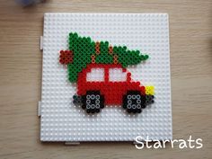 a red truck with a christmas tree on it is made out of legos and beads