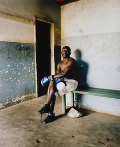 a man sitting on a bench in a run down building with no shoes or clothes