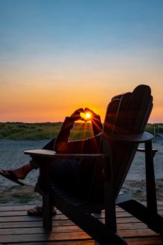 a person sitting in a chair with the sun setting behind them